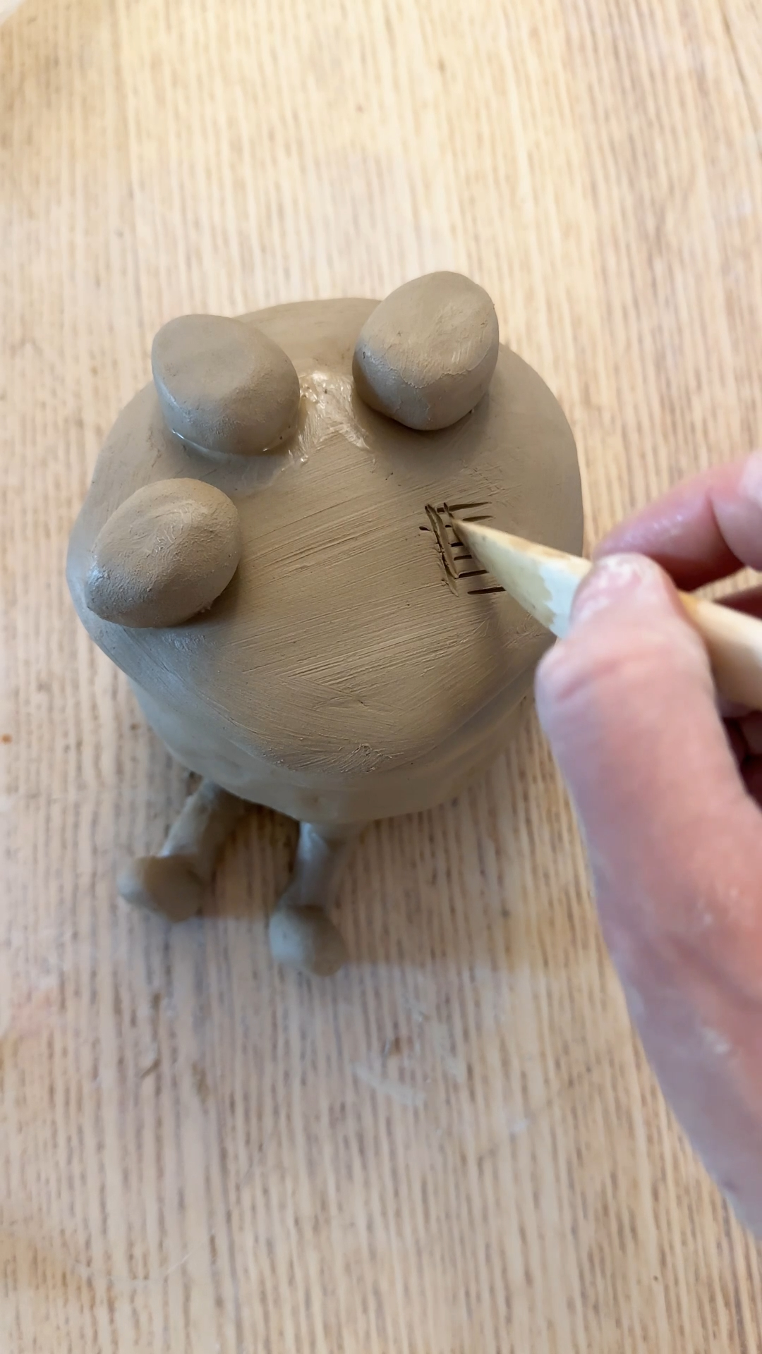 clay icing layer draped over cake top with five clay strawberries being added