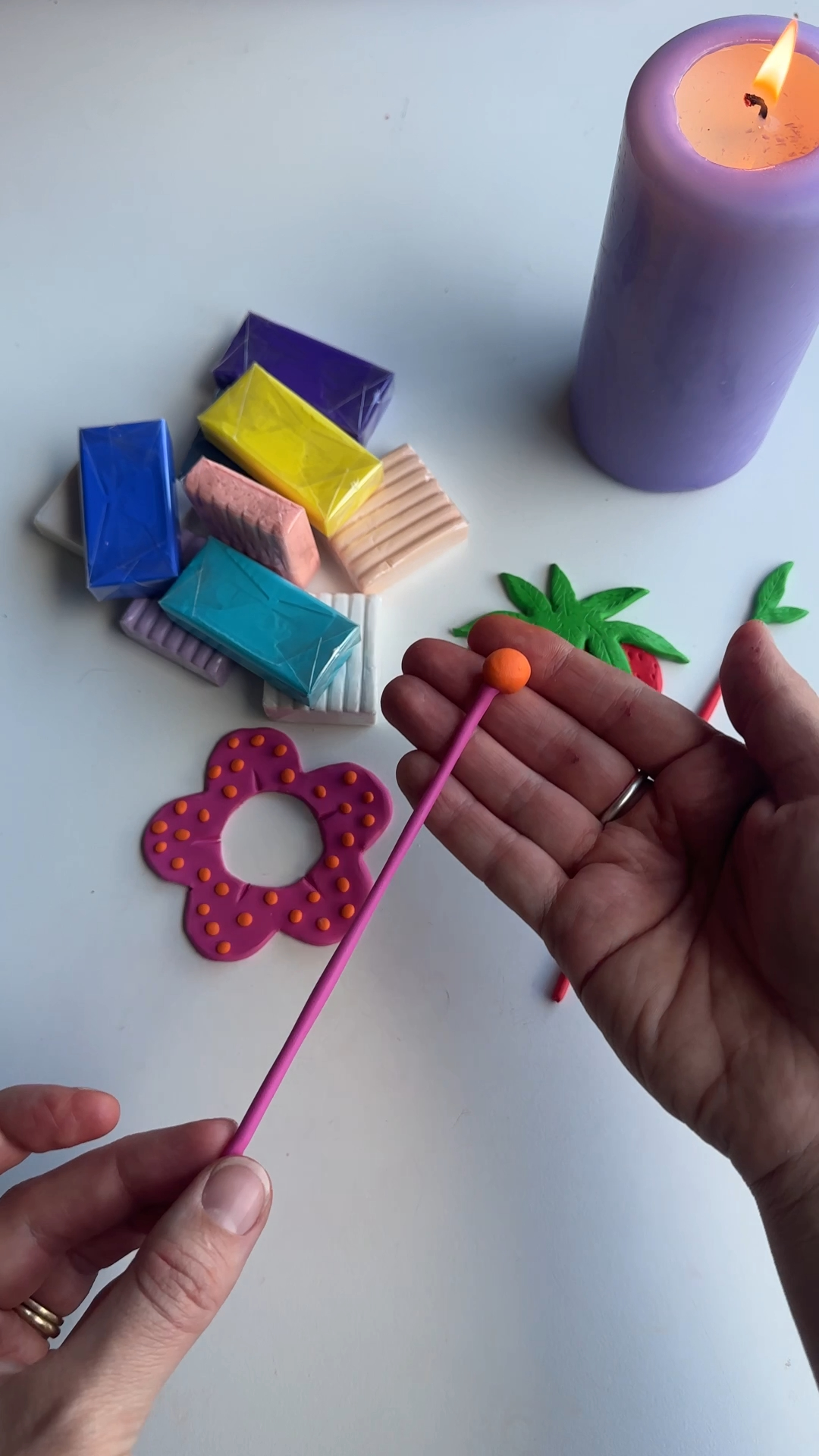 attaching a orange tip onto a long thin polymer clay pin for a diy flower hair accessory