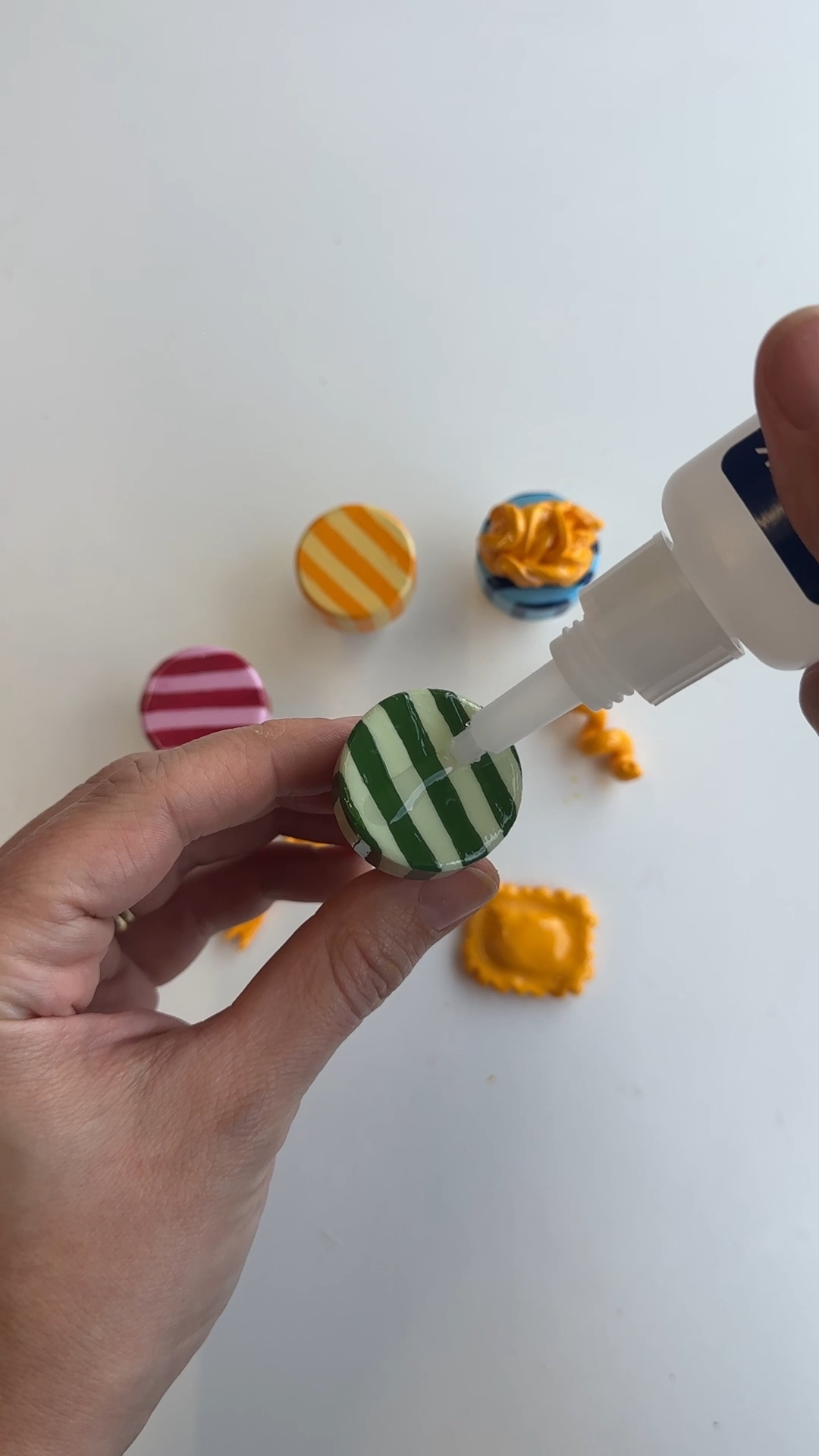 super glue being applied to the painted top of a wine stopper