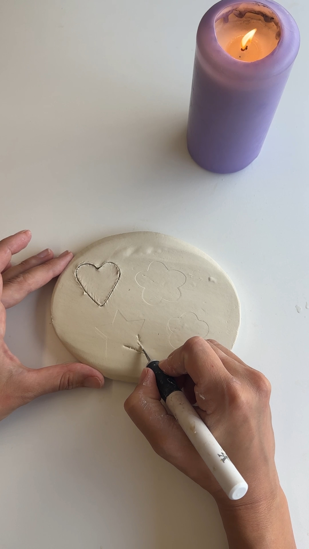 hand cutting heart, flower and star templates from a rolled air dry clay slab