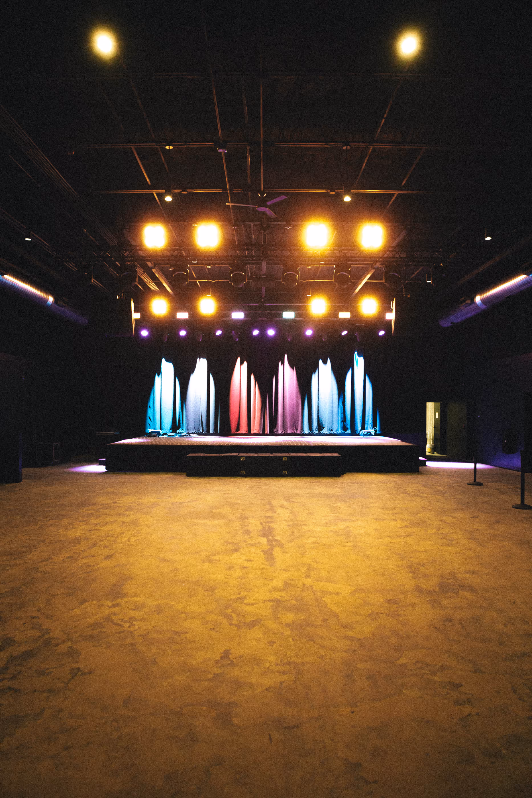 The main concert hall at Live at Madrid's with lit stage, ready for a private event