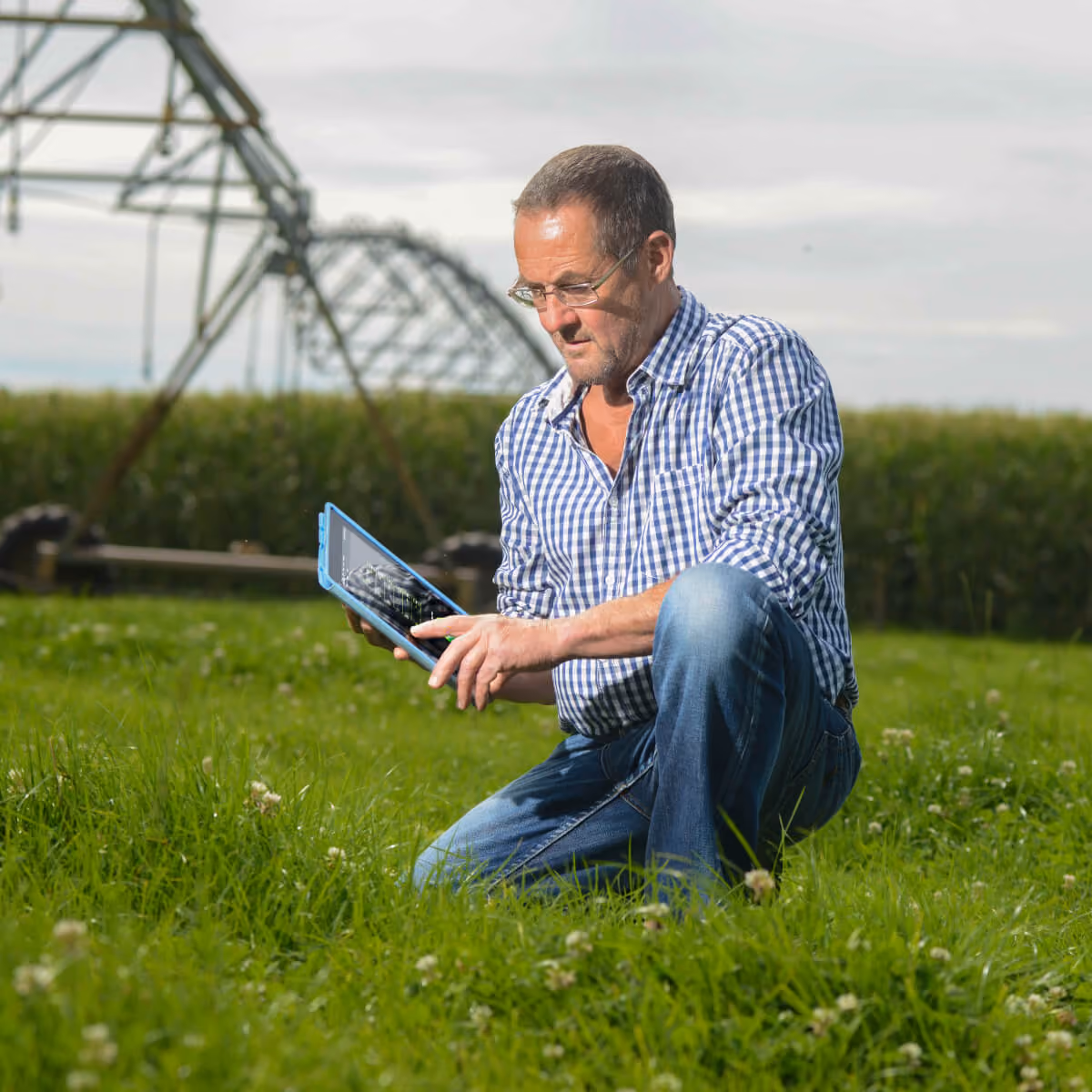 Technician using a handheld device beside a pivot