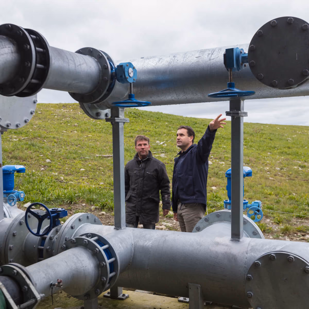 Technicians inspecting large pumping pipework