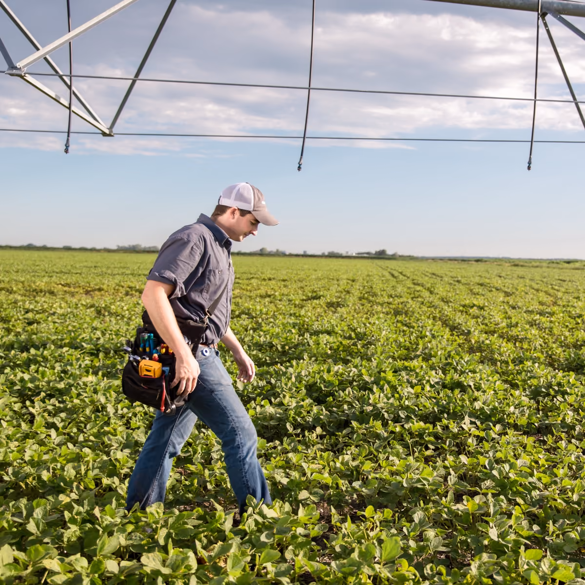 Worker checking irrigation beneath a centre pivot