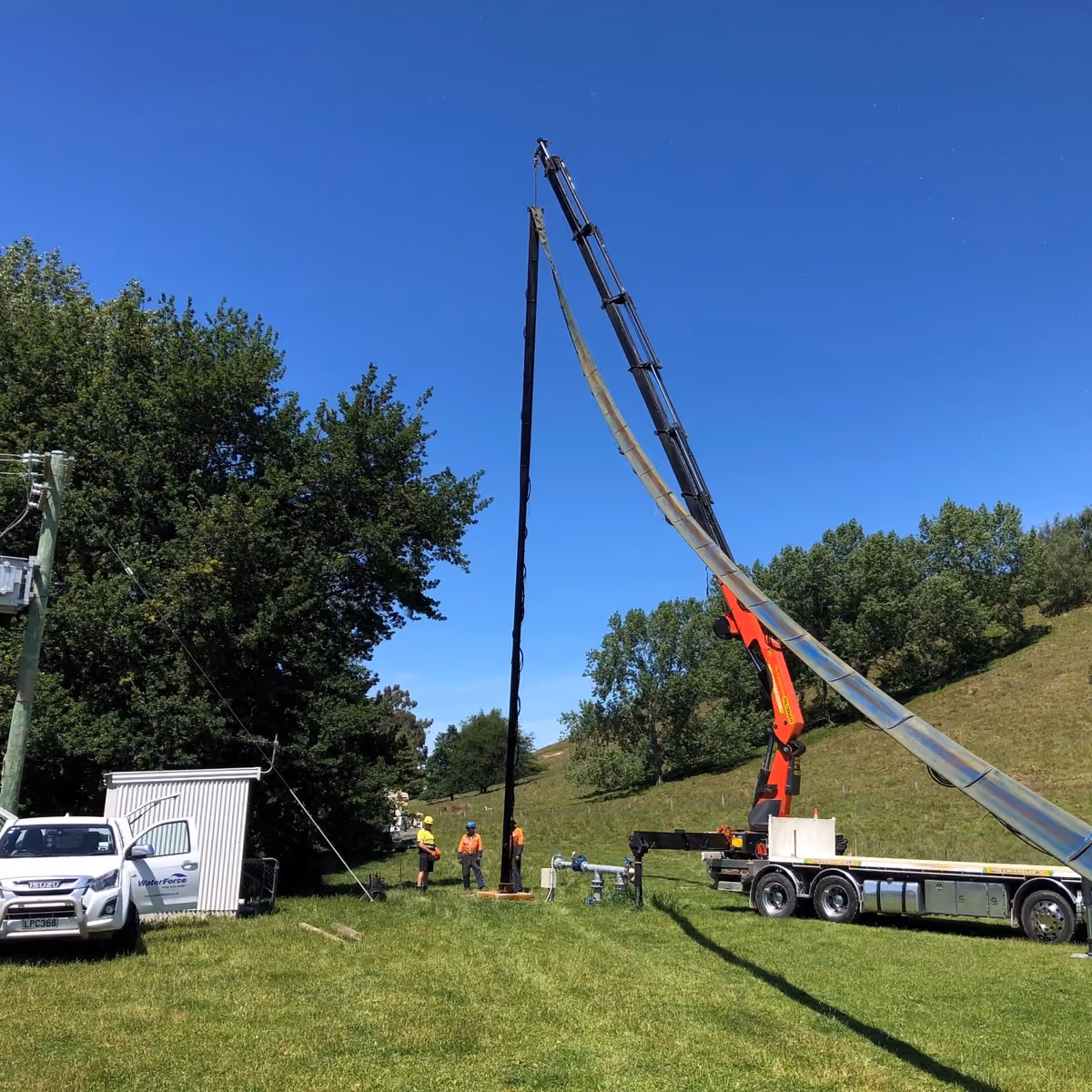 Crane lifting bore equipment beside WaterForce vehicles