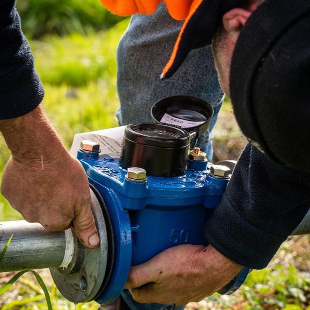 Technicians working on a water meter connection