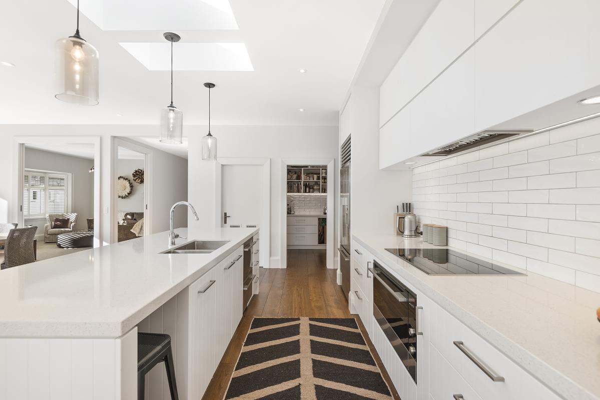 Modern kitchen with white cabinetry, marble benchtop, pendant lighting and butler's pantry