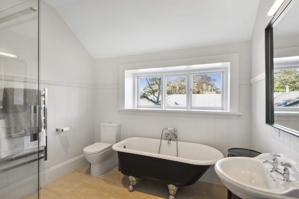Ensuite bathroom with white double vanity, large mirror and natural light