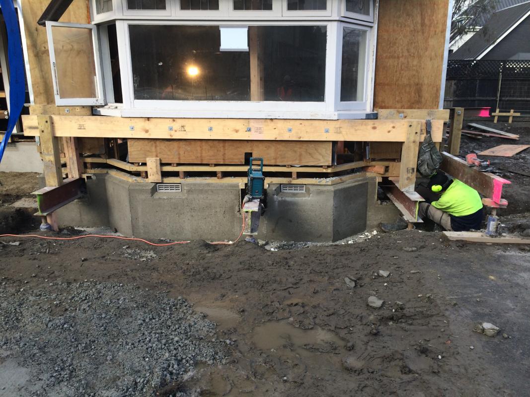 Under-construction view of the Fendalton renovation showing the wrap-around deck framing and rear extension in progress