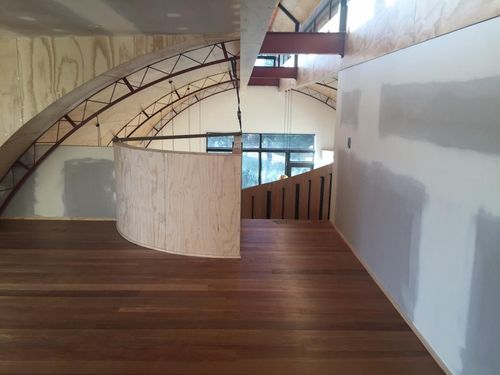 Completed interior of the barn conversion with recycled heart rimu flooring, curved ceiling, finish grade structural ply walls and natural light