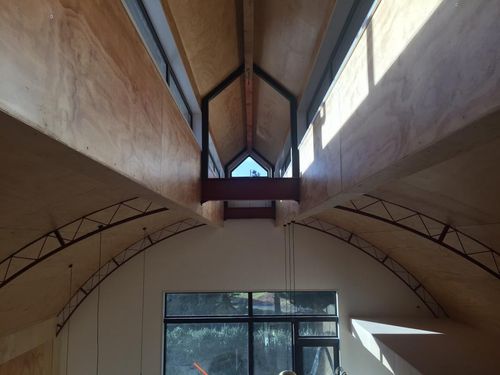 Interior view of the completed curved ceiling with Velux skylight windows flooding the atrium with natural light