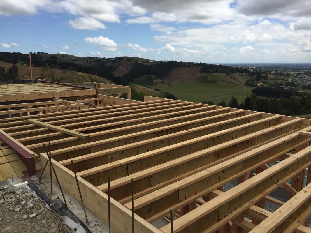 Aerial construction view showing the roof structure and framing of the Cashmere Heights home on the hillside