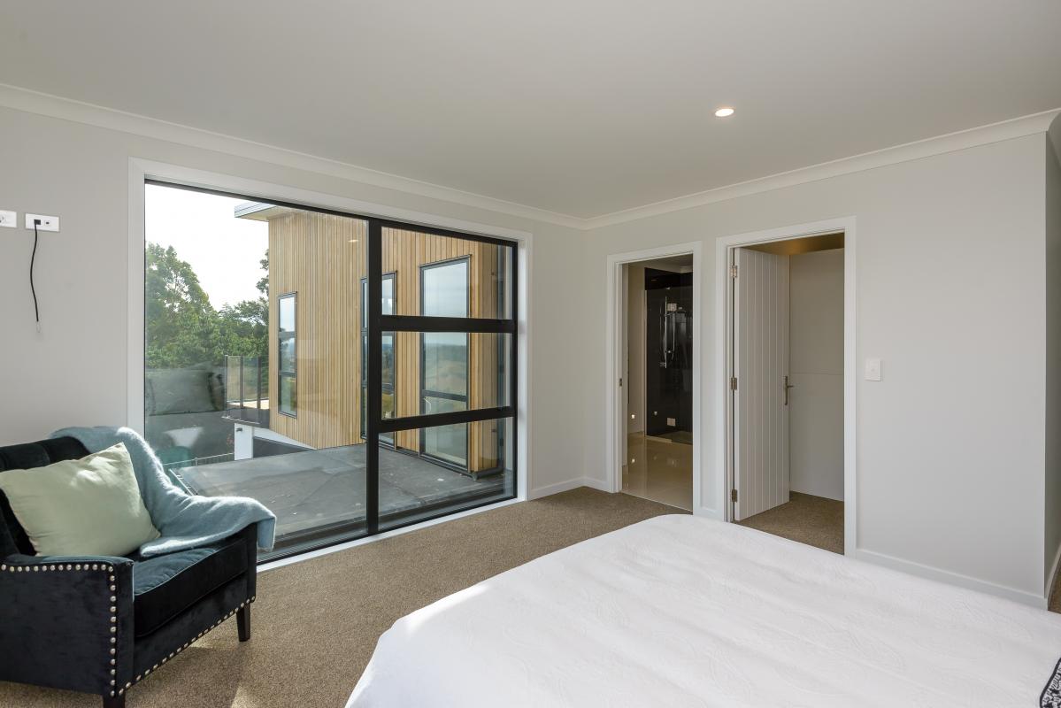 Hallway with white walls, timber flooring and natural light from a ceiling window