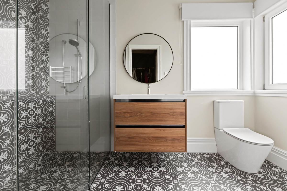 Renovated bathroom with grey tile, timber vanity, white basin and natural light