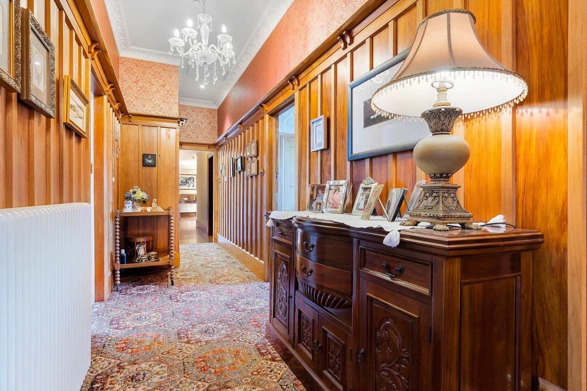 Period-style dining area with chandelier, rimu joinery, matai flooring and classic furnishings