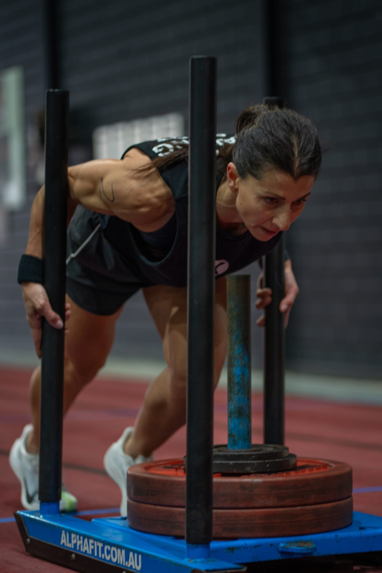 Athlete pushing a weighted sled at RevX Fitness Society in Parramatta