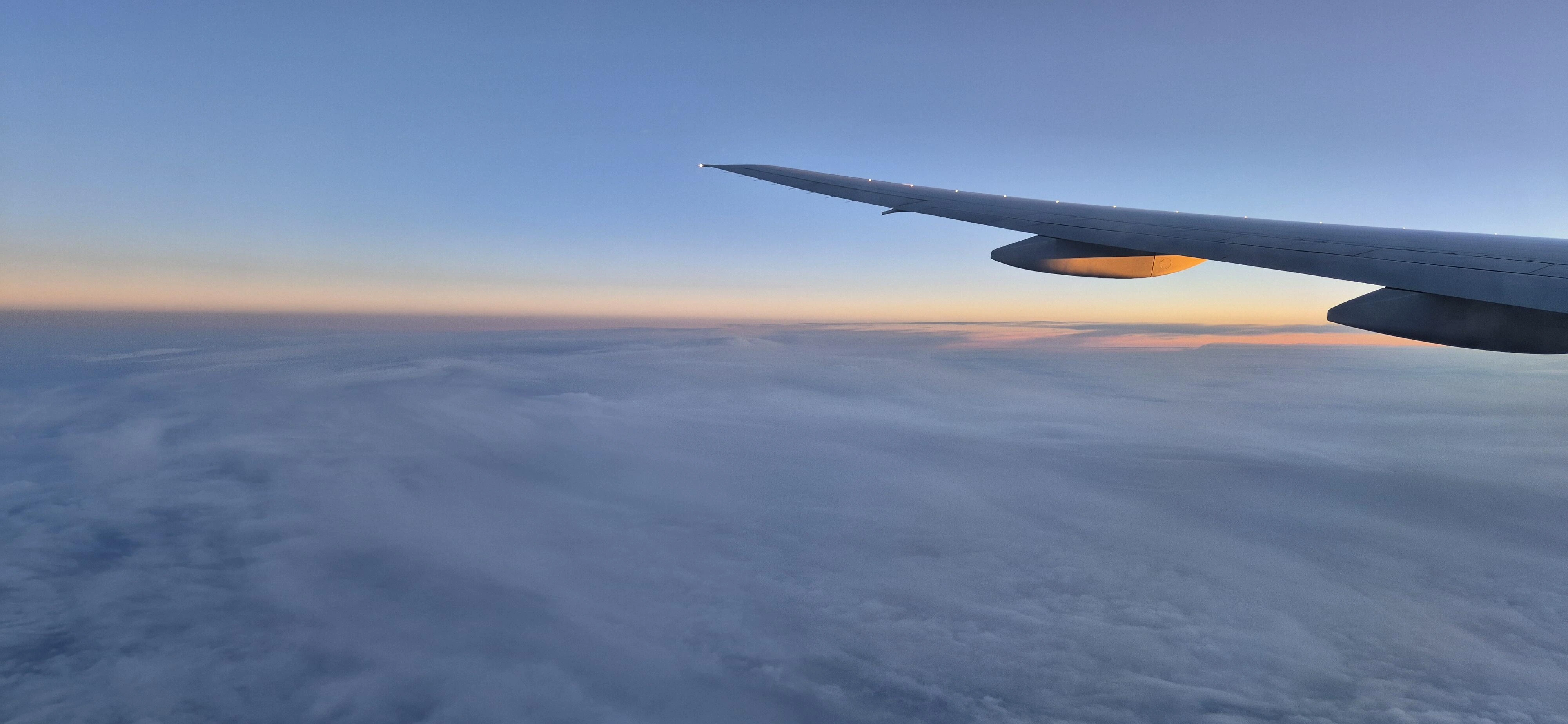 Flugzeug und Sonnenaufgang über den Wolken