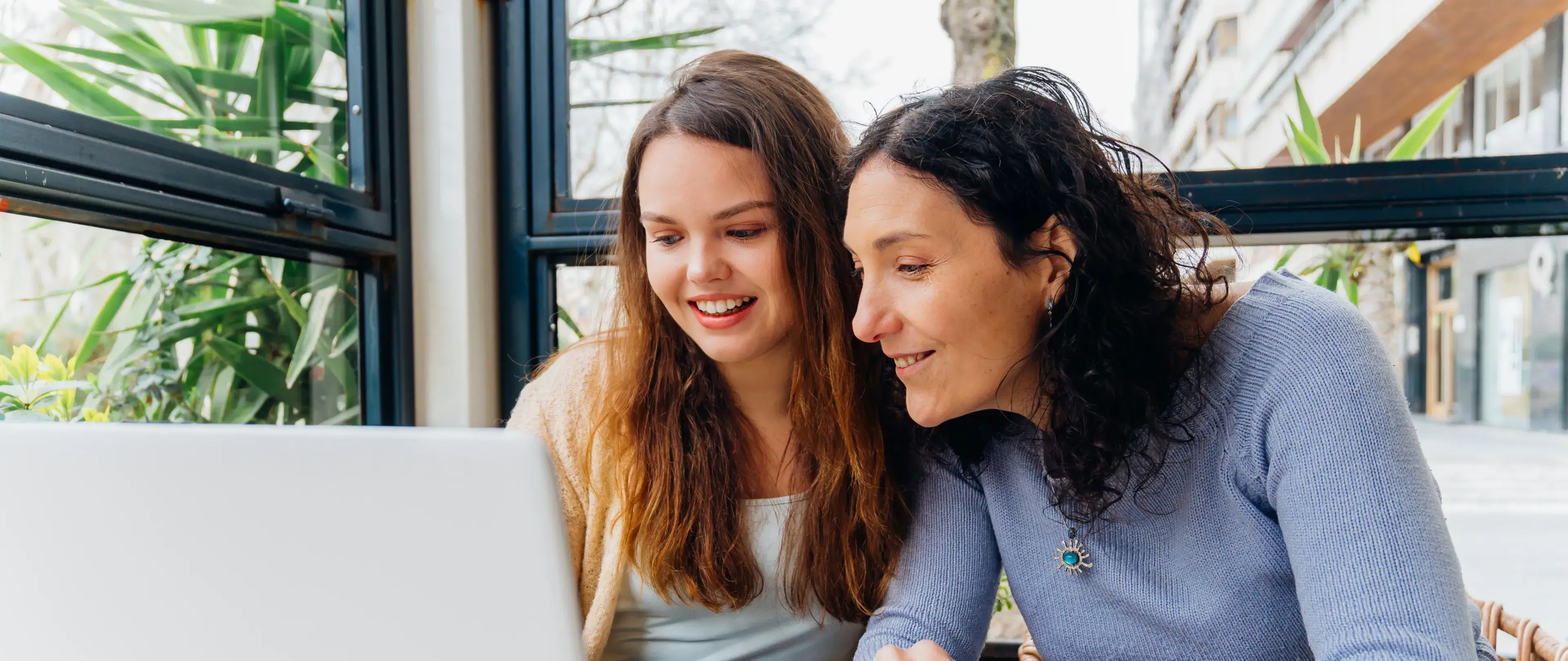 Image of two women consulting over a laptop.