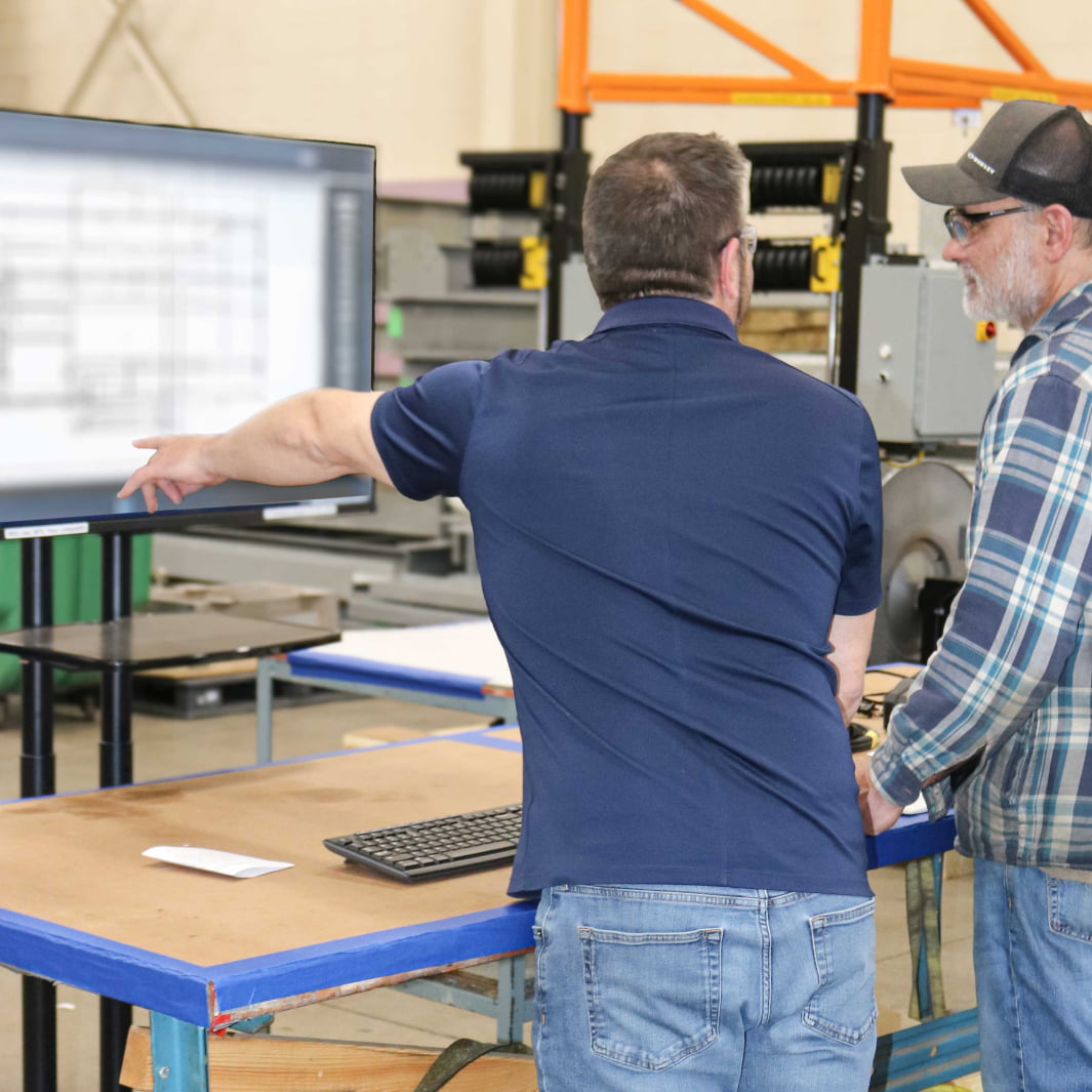 Project team reviewing manufacturing system specifications and engineering documentation