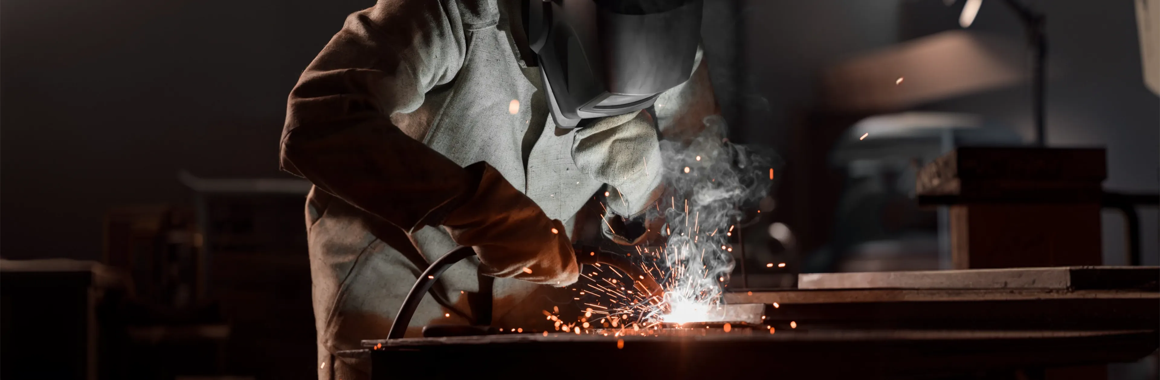 Certified welder fabricating a precision metal component for defense and government applications