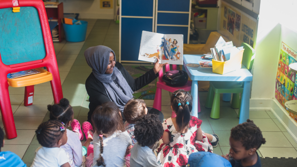 an early childhood educator reading a book to young children supports their learning