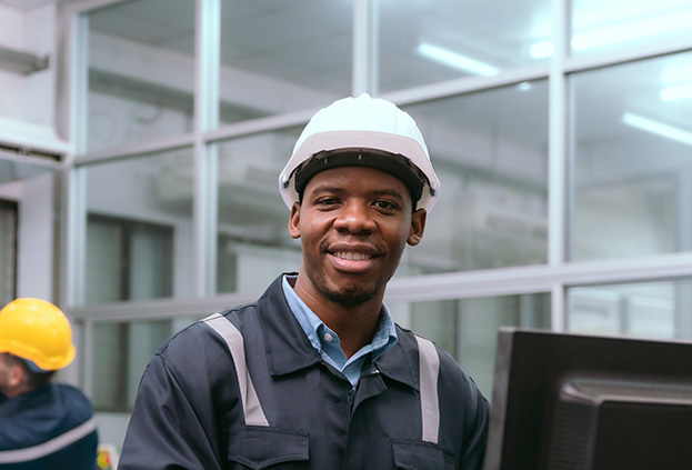 An engineer uses a computer to view data in a factory