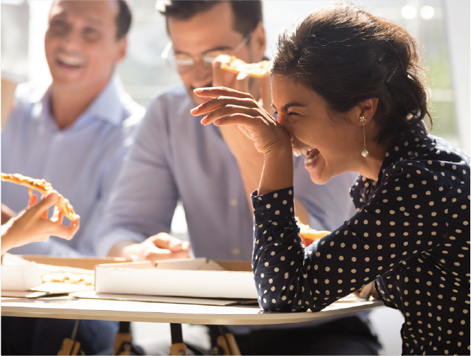 Employees eating lunch and laughing together
