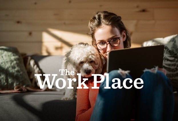 Employee on Zoom, with a dog peering over her shoulder