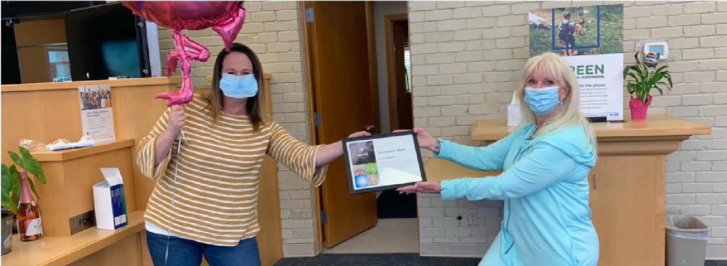 Heritage Bank team members share a recognition moment with an award certificate in one of their branch offices