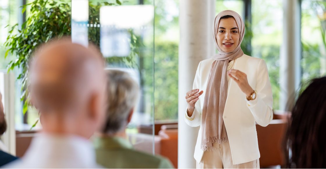 An employee leading a meeting with their team in an office.