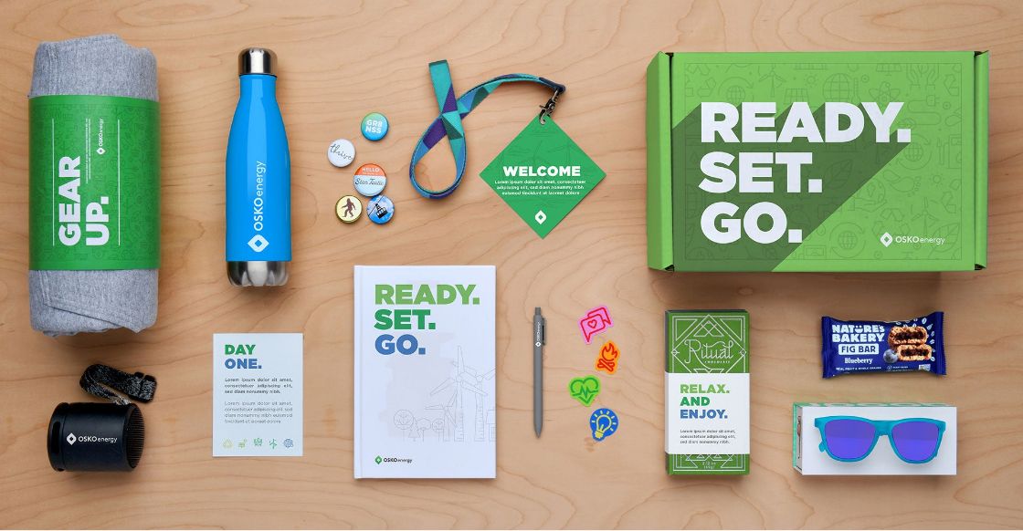 An onboarding swag box that includes branded company gear like a water bottle, sweatshirt, candy and stickers.
