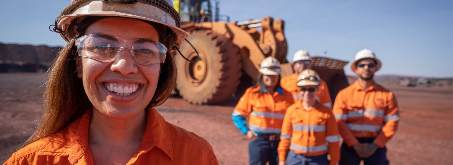 BHP employees at a mine site smiling