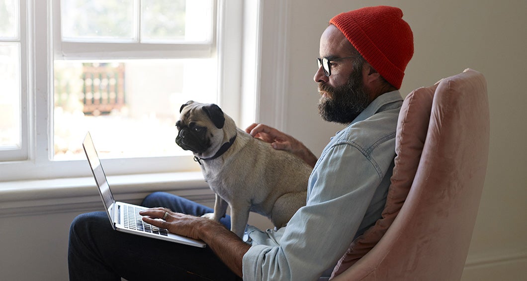 Remote employee working on a laptop with their dog