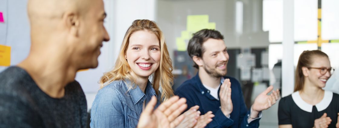 A team of employees clapping and celebrating together