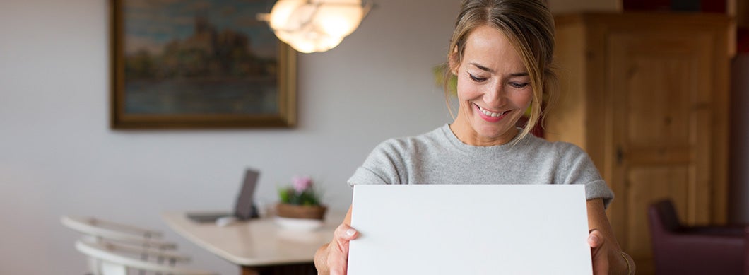 A woman opening a parcel at home
