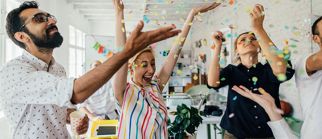 Men and women celebrating in an office
