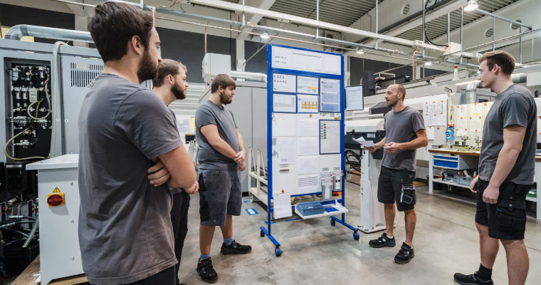 A manufacturing team connecting during a team huddle.