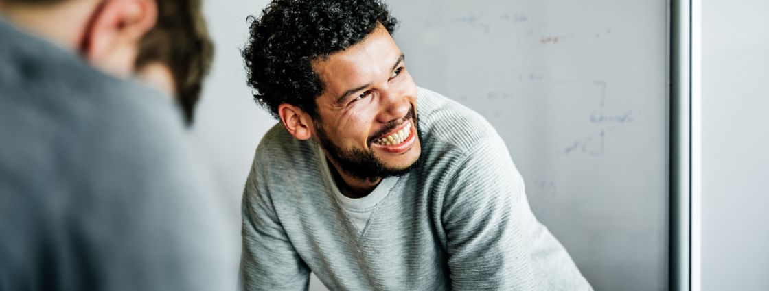 An employee laughing in front of a white board
