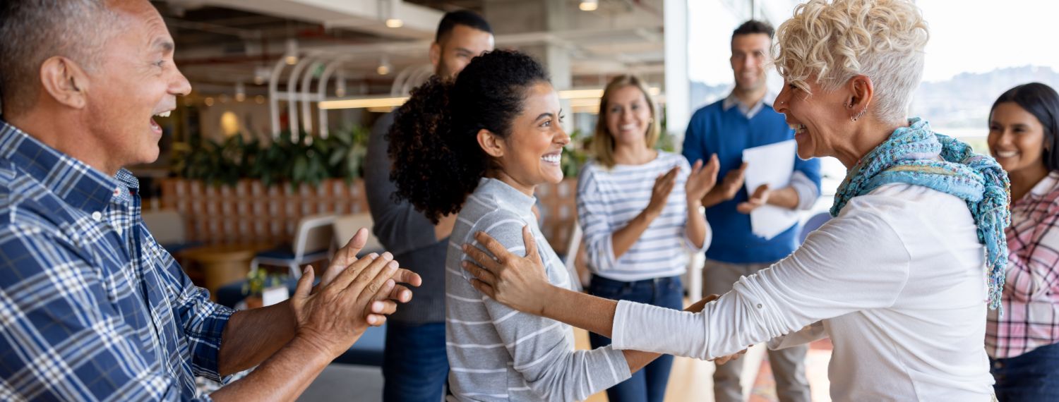 A leader recognizing an employee in front of their team.