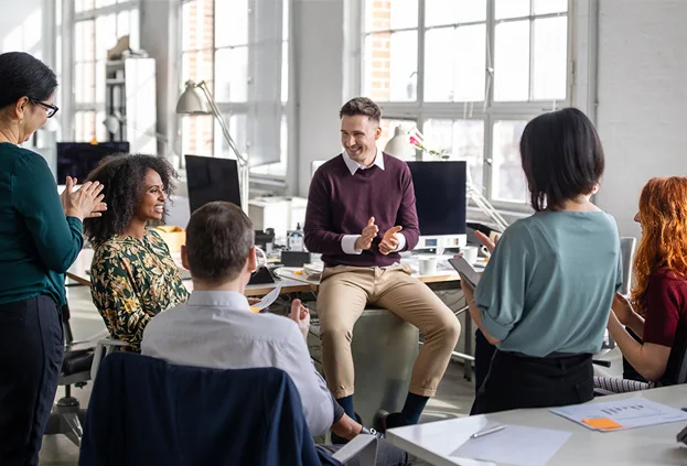 A team gathering together in office to celebrate a work anniversary for a colleague