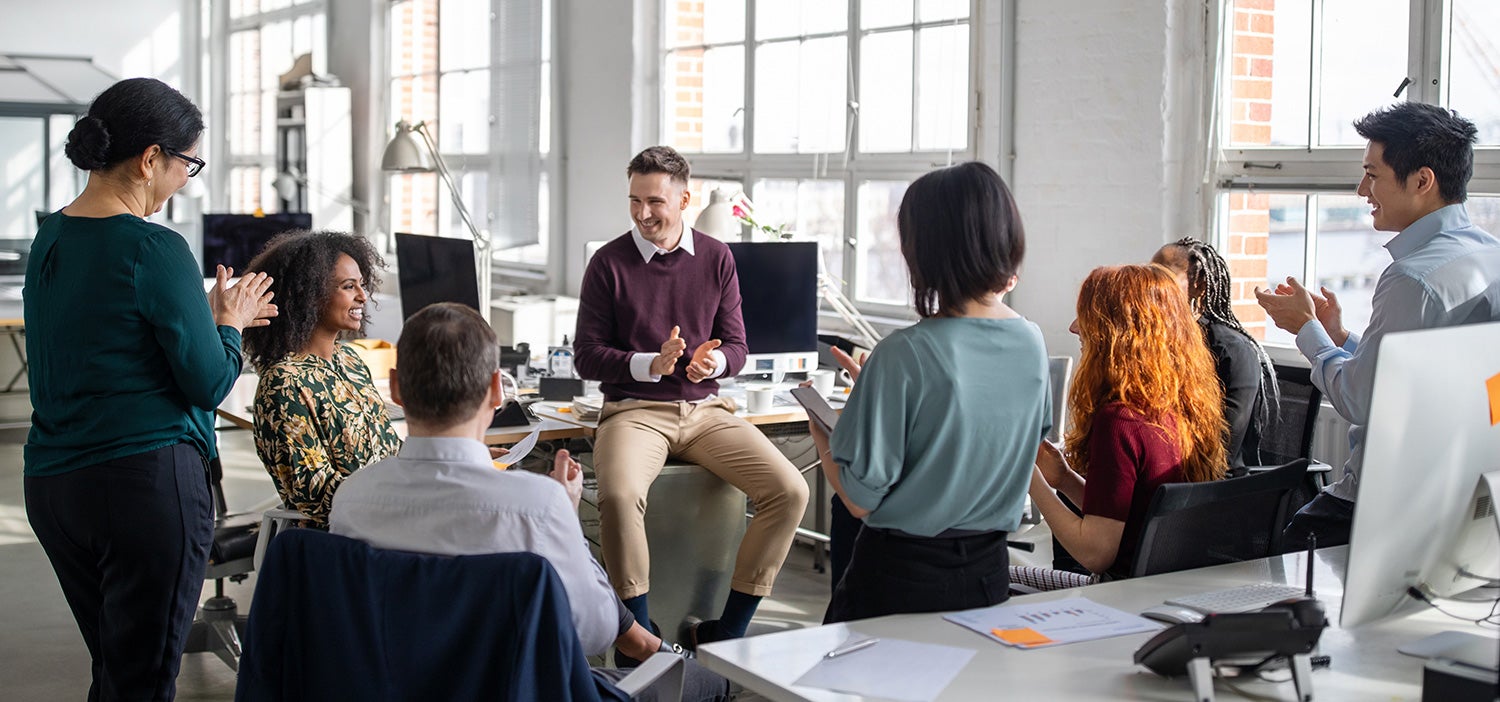 A team gathering together in office to celebrate a work anniversary for a colleague