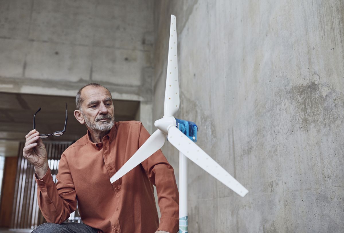 Employee in an office looking at a wind turbine model