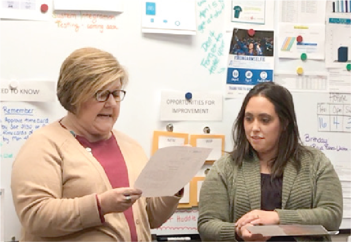 Healthcare professionals handing out service award through O.C. Tanner HR software.