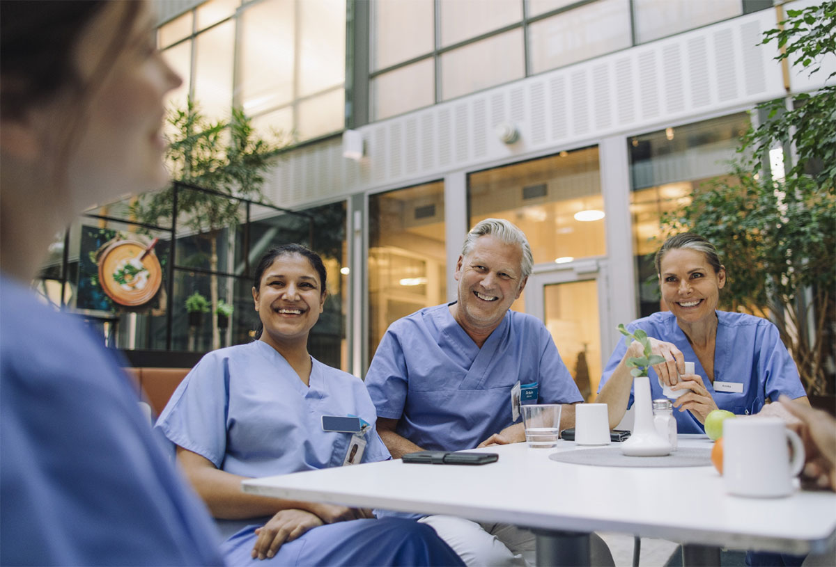 Doctors sitting at table in the cafeteria of a hospital