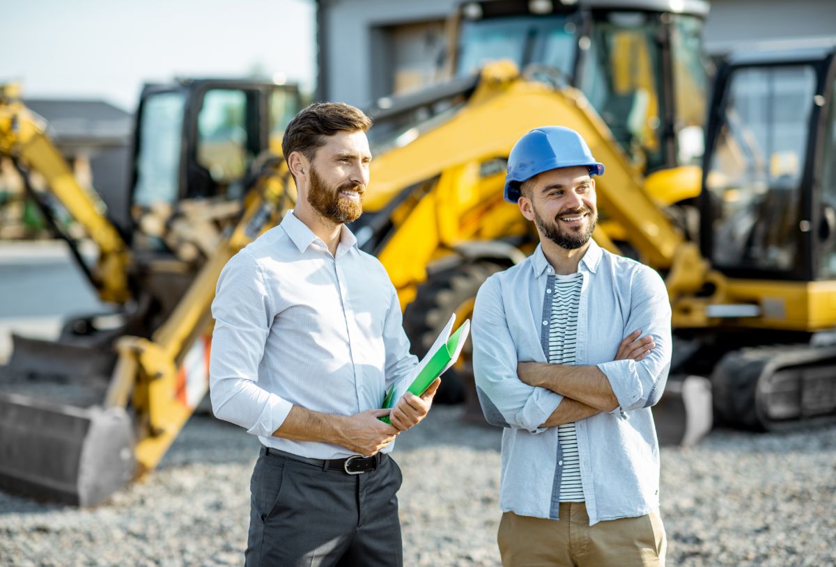 Workers standing amongst heavy construction equipment