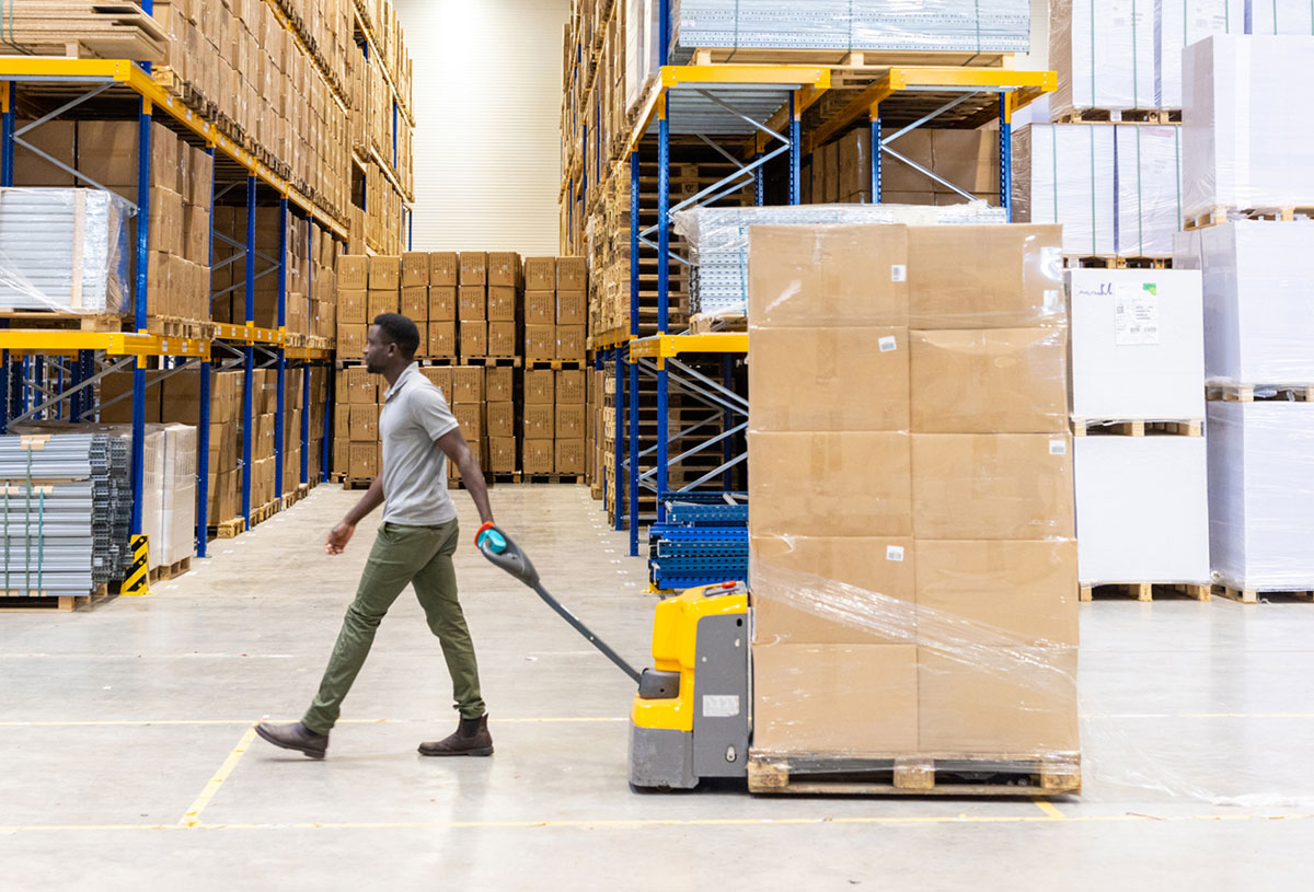 A worker moving cargo in a distribution warehouse
