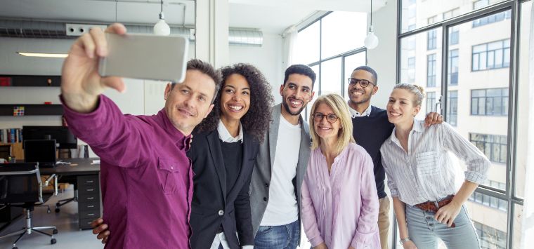 Employees in an office together taking a photo