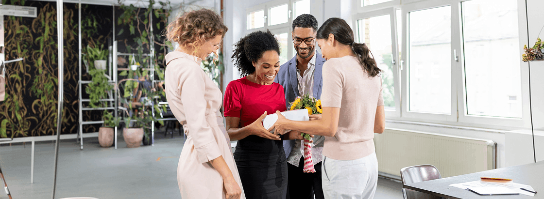A group of employees giving a gift.
