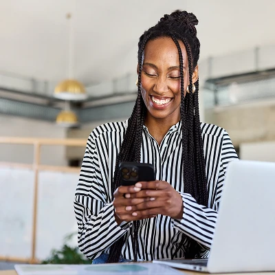 An employee in an office looking at their phone.