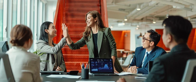 Des employés partageant un high five lors d’une réunion